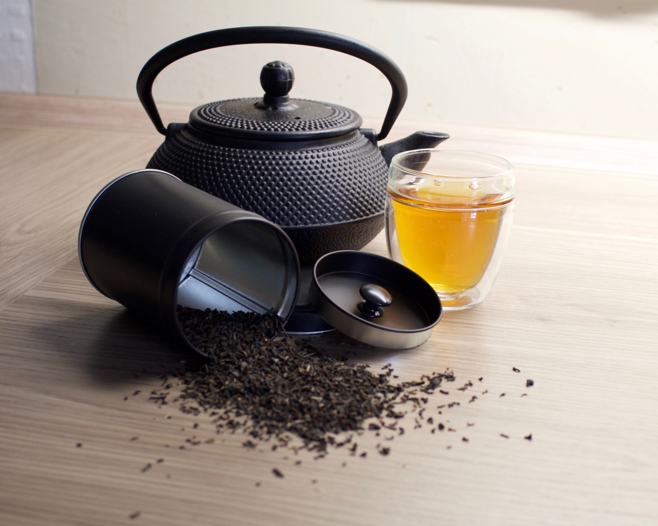 Черный чай на столе с чайником и чашкой