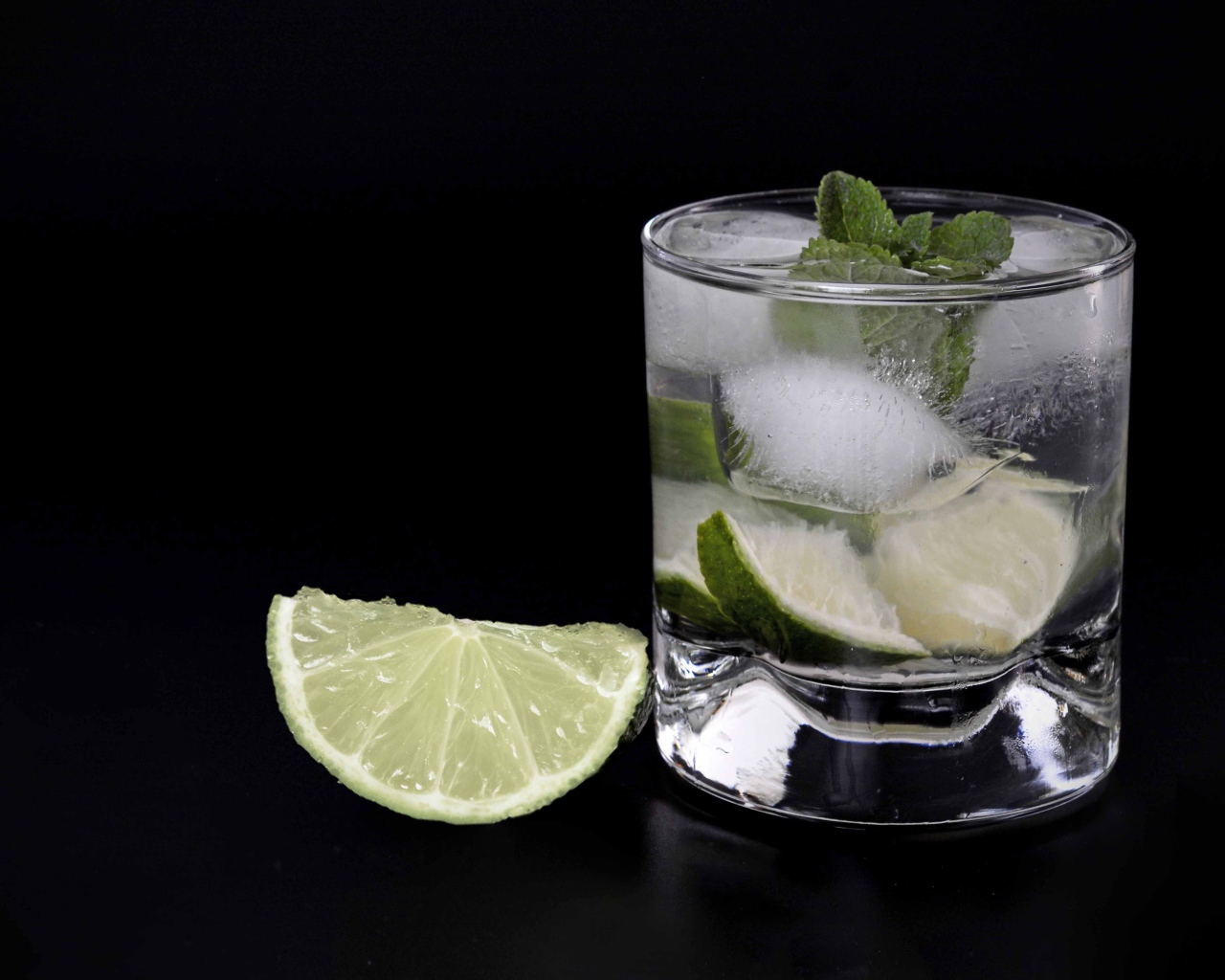 Коктейль кайпиринья на черном фоне с кусочком лайма