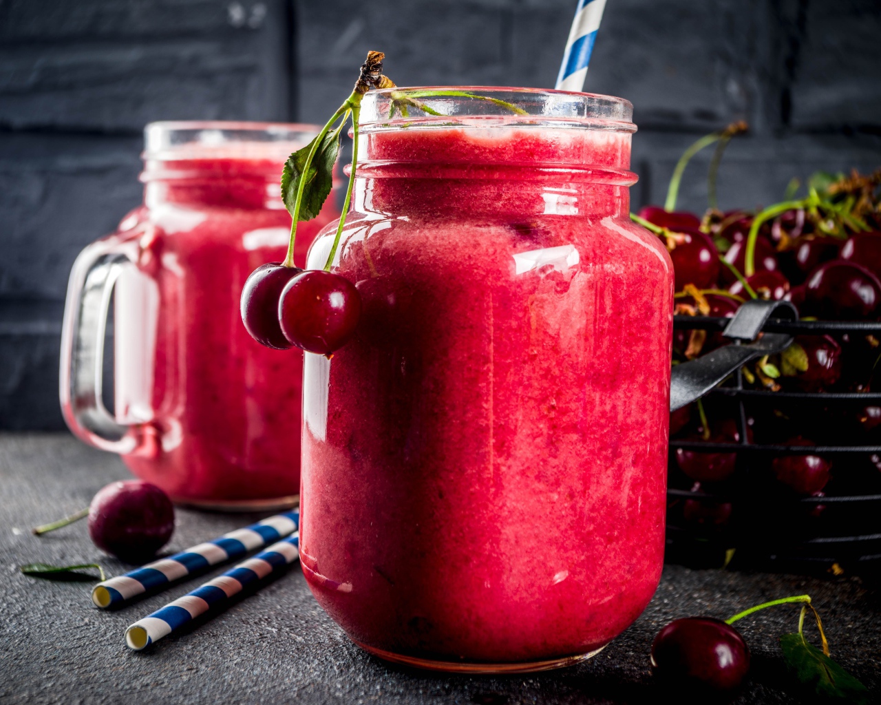 Вишневое смузи в стеклянной банке на столе с ягодами