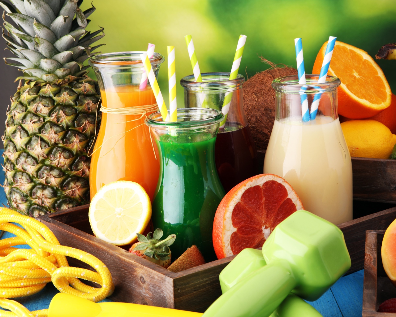 Коктейли в бутылках с трубочками на столе фруктами