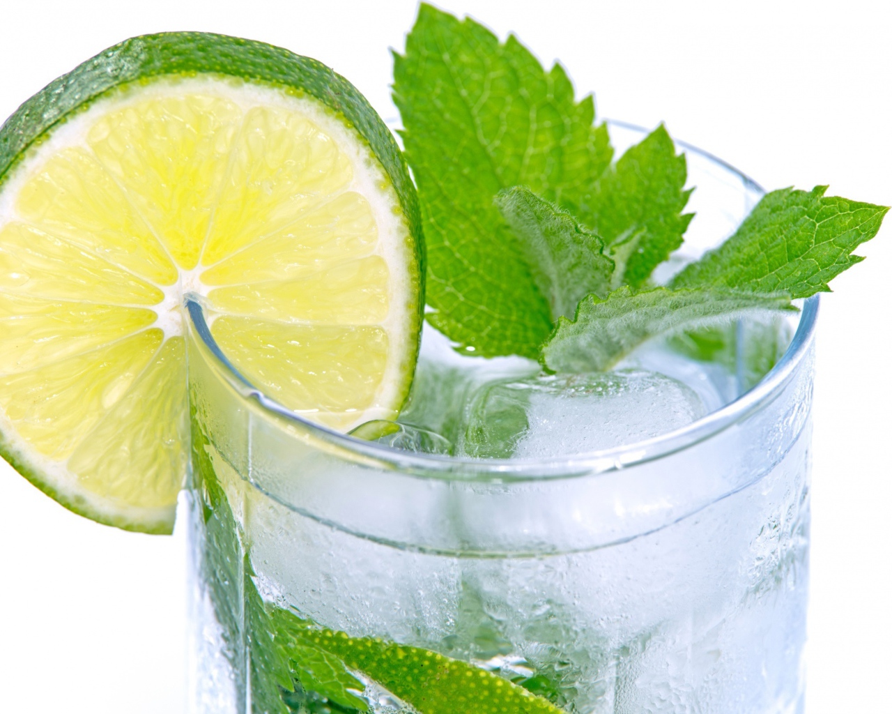 Стакан с освежающим напитком с мятой и лаймом на белом фоне