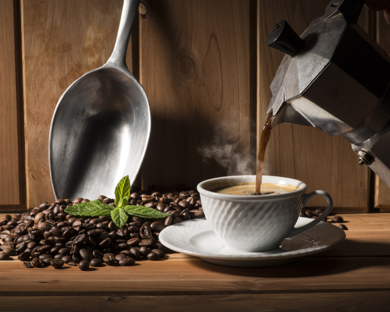 Горячий кофе наливают в чашку на столе с кофейными зернами