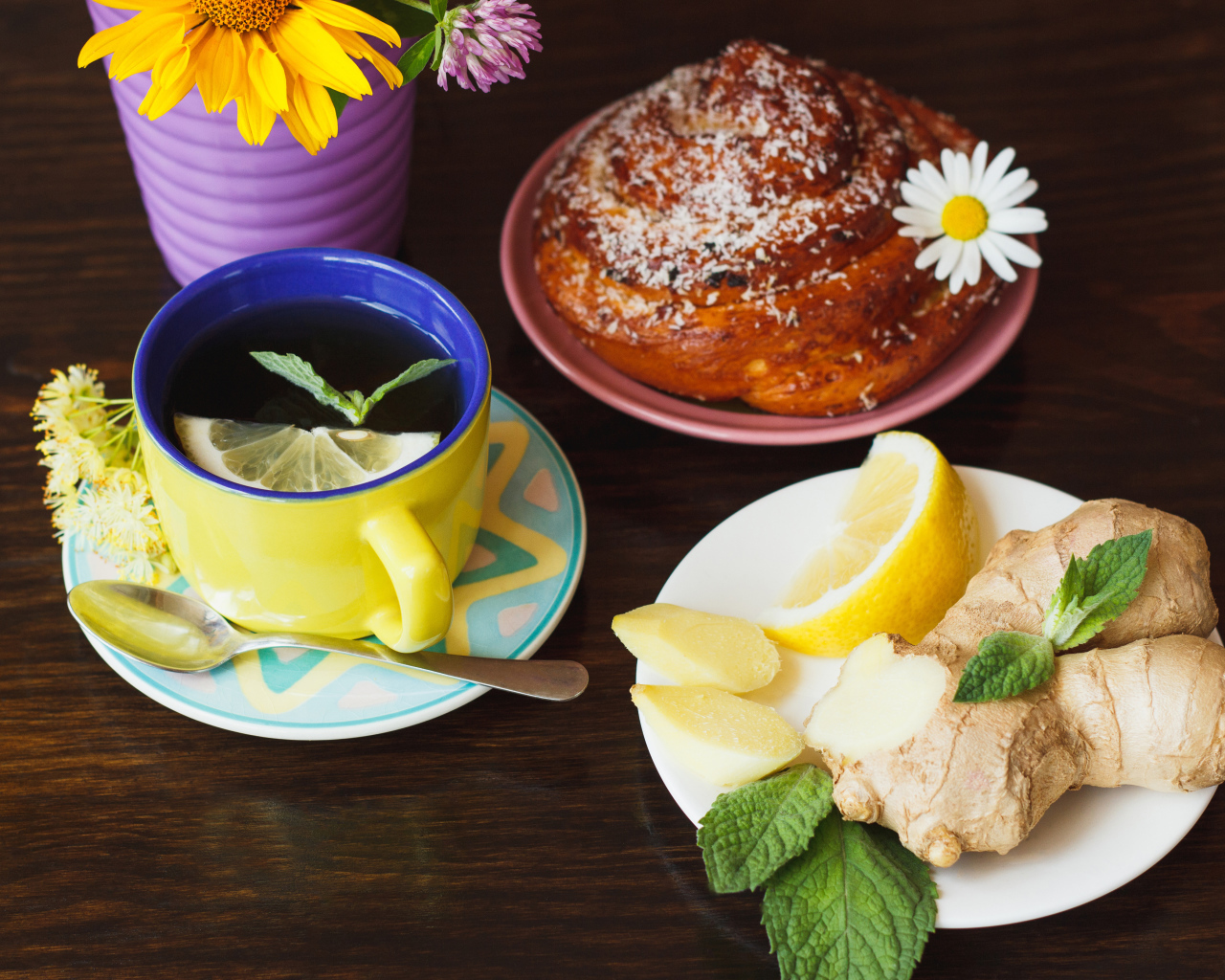 Липовый чай с имбирем и лимоном на столе со свежей булочкой