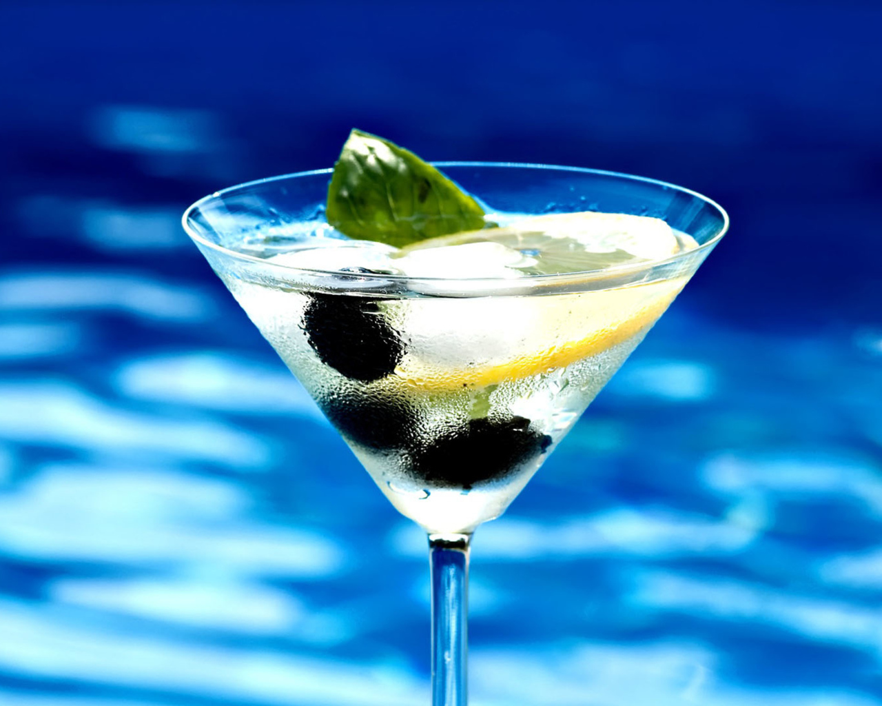 Мартини в бокале с лимоном и оливками 