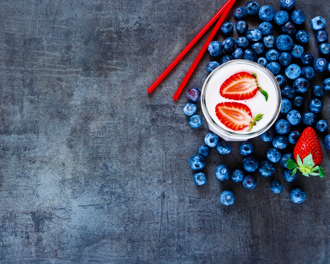 Молочный коктейль с клубникой и черникой на столе 