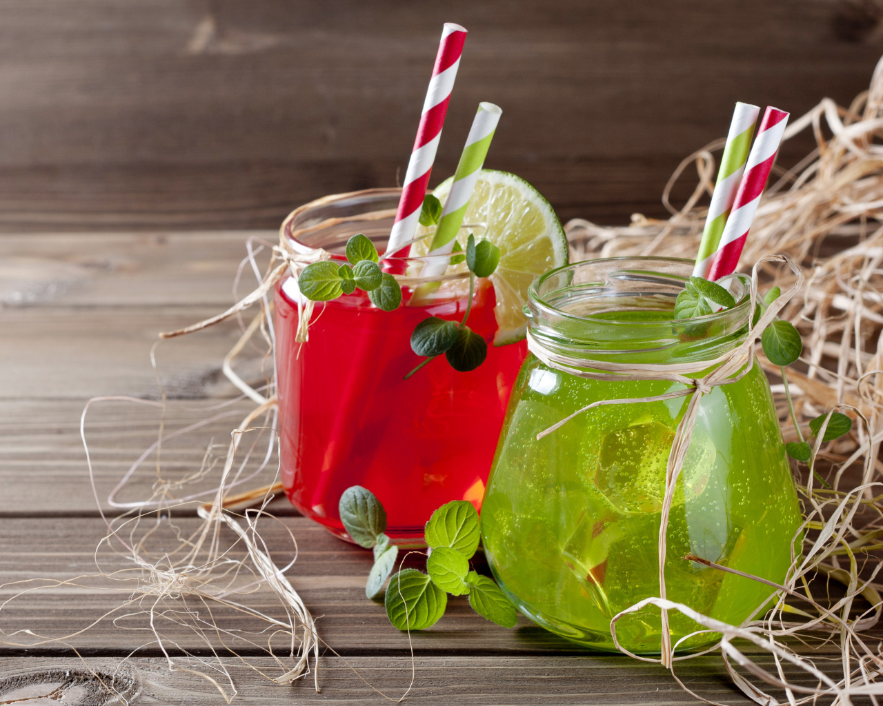 Две банки с коктейлями на деревянном столе с соломой