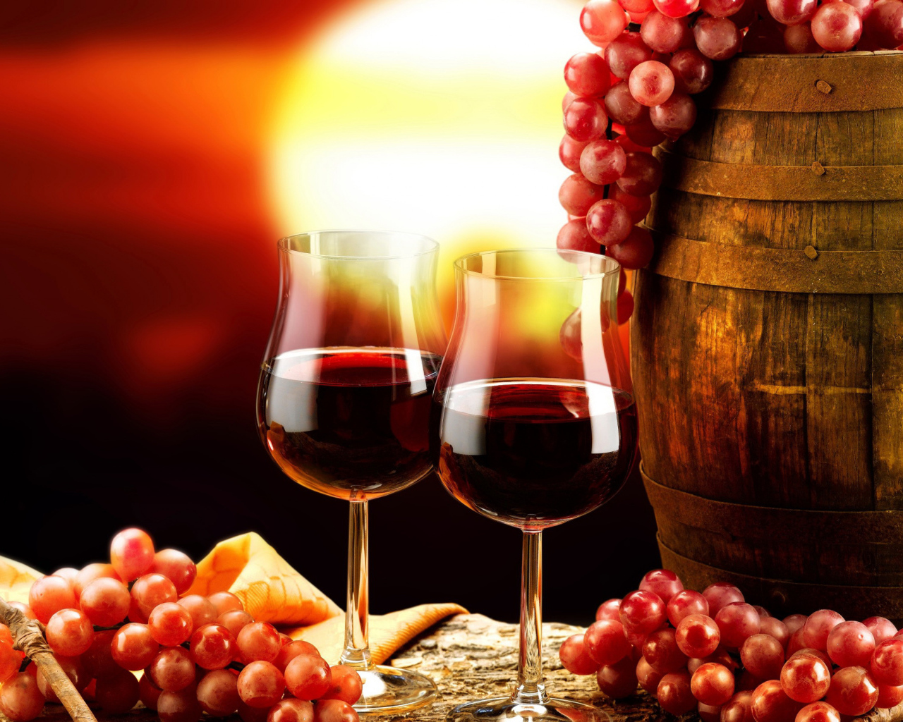Два бокала вина на столе с бочкой и гроздьями винограда 