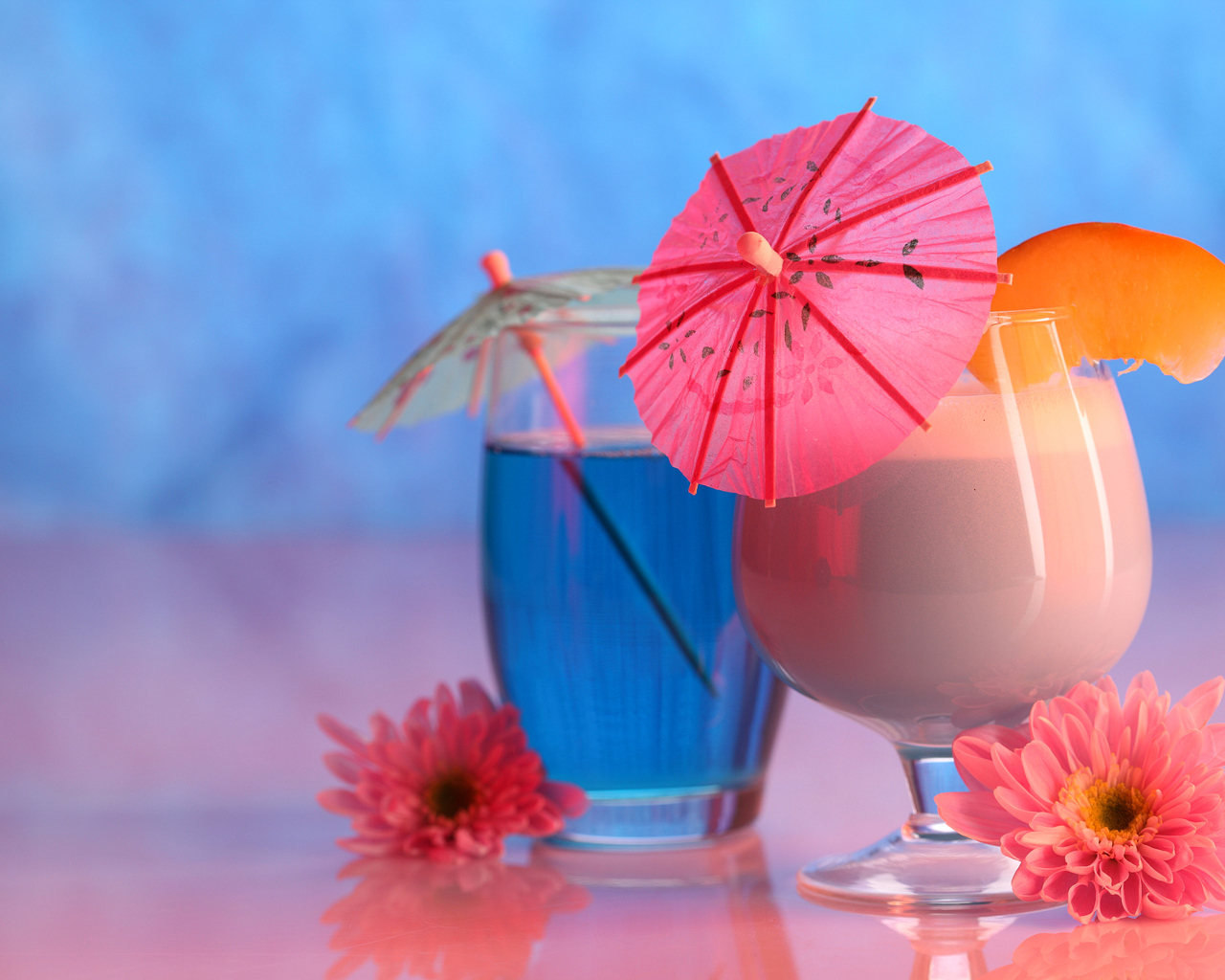 Два бокала с коктейлем на столе с розовыми цветами хризантемы