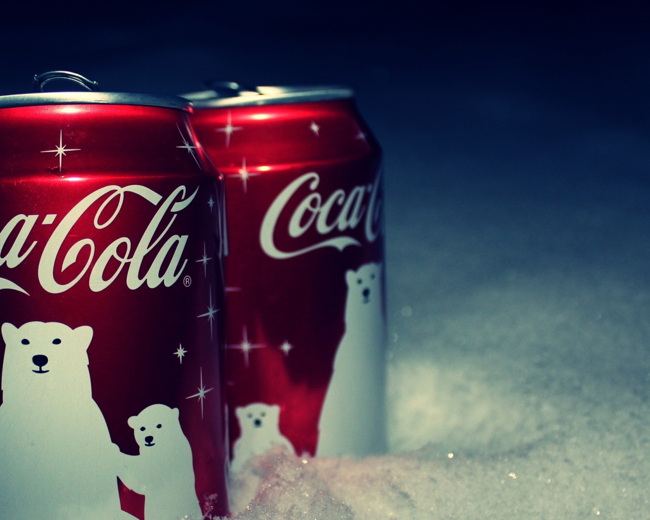 Две красные банки напитка Кока Кола стоят на снегу
