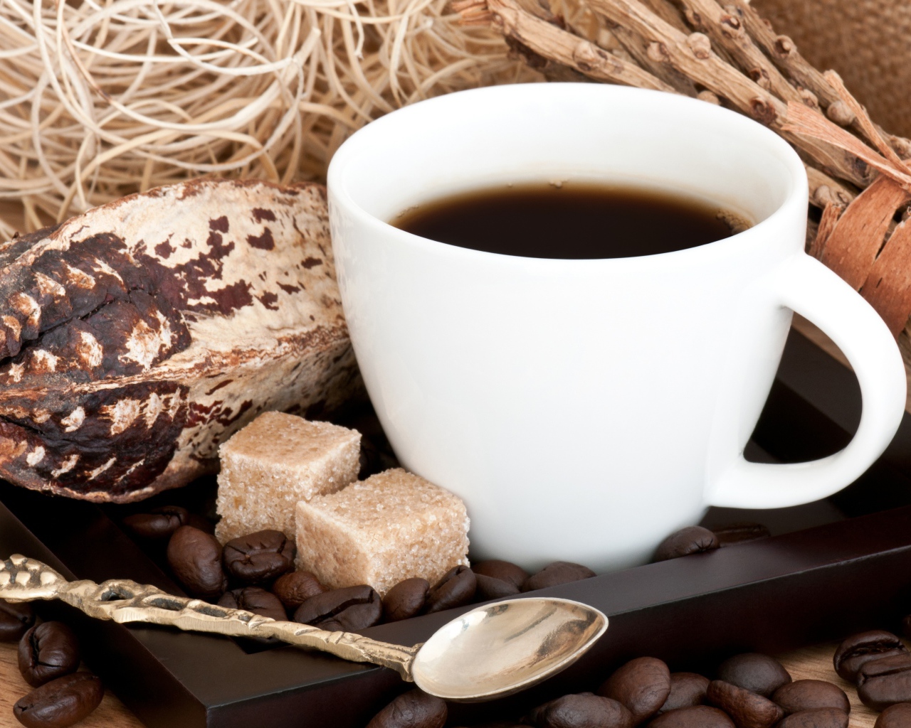 Белая чашка кофе с зернами и кусочками сахара на столе 