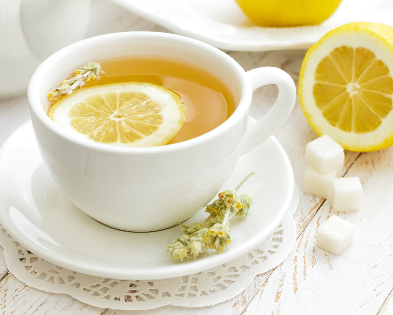 Белая чашка цветочного чая с лимоном