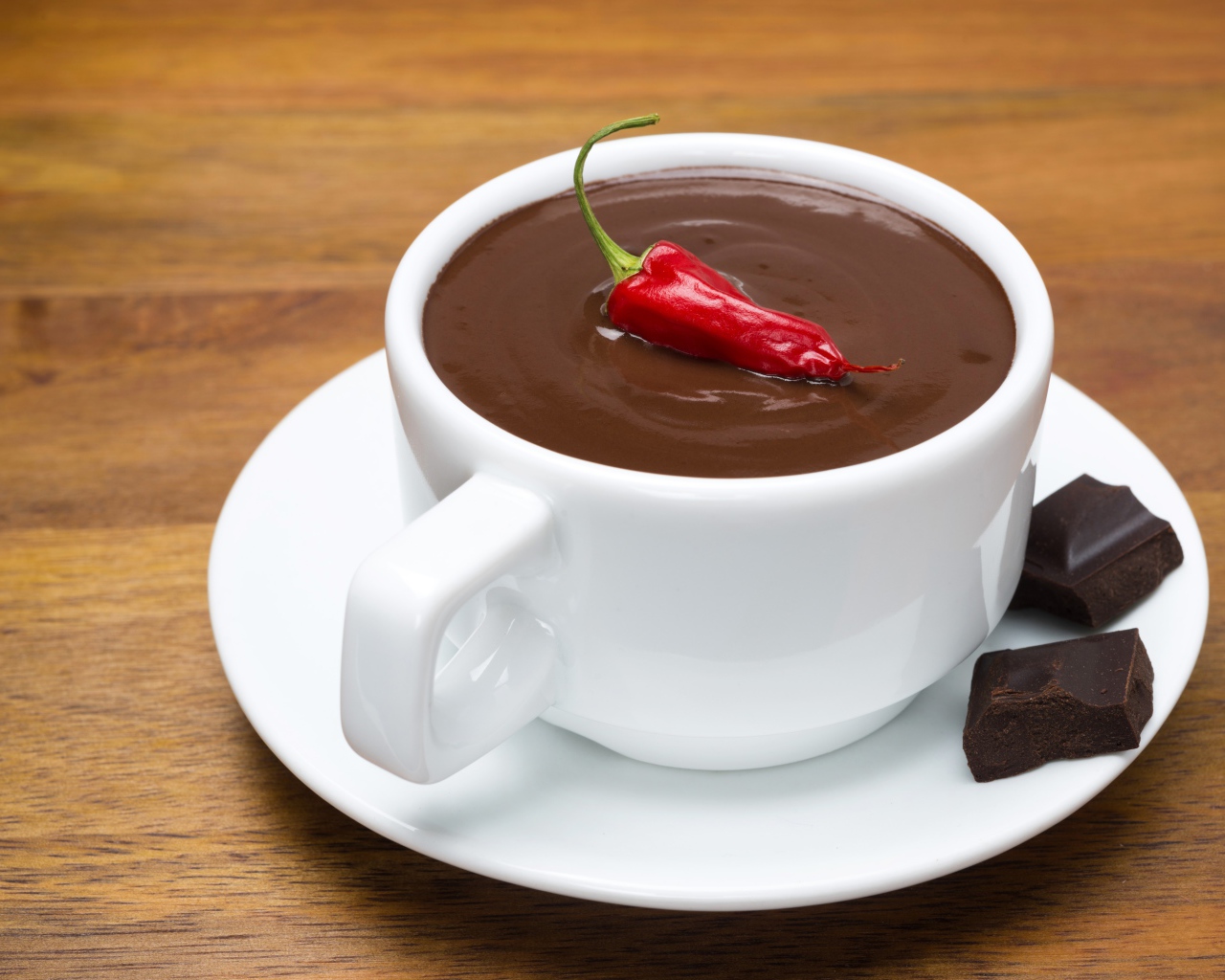 Белая чашка горячего шоколада с красным перцем