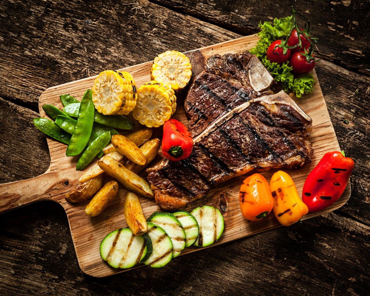 Кусок мяса на разделочной доске с овощами