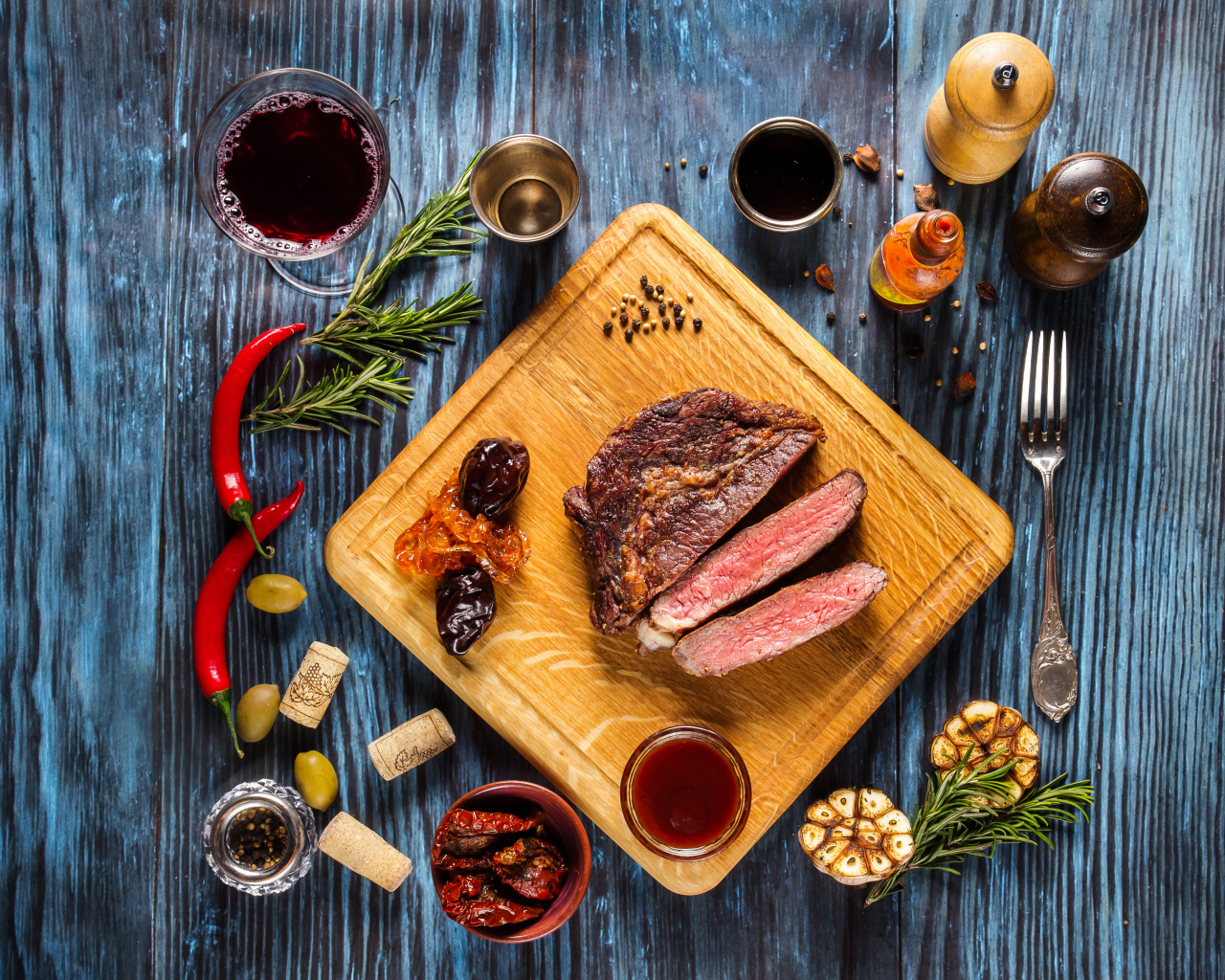 Кусок мяса на столе со специями и стаканом вина