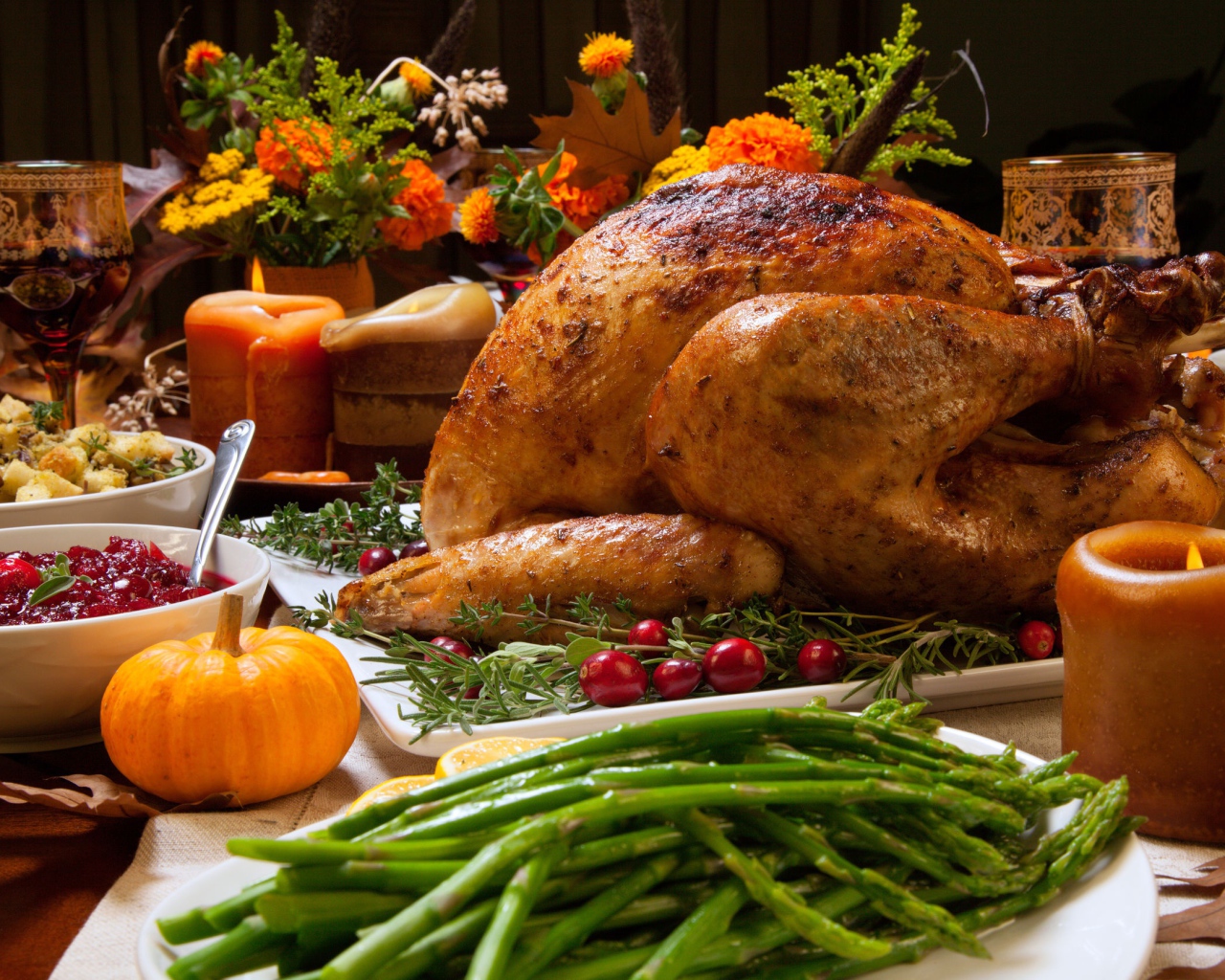 Аппетитная запеченная курица с зеленой спаржей и угощениями на праздничном столе