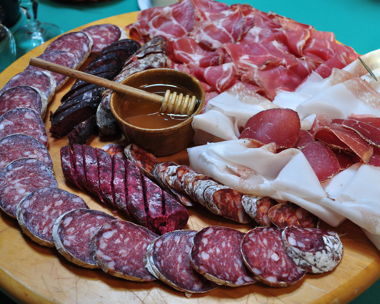 Аппетитная мясная нарезка на разделочной доске с медом