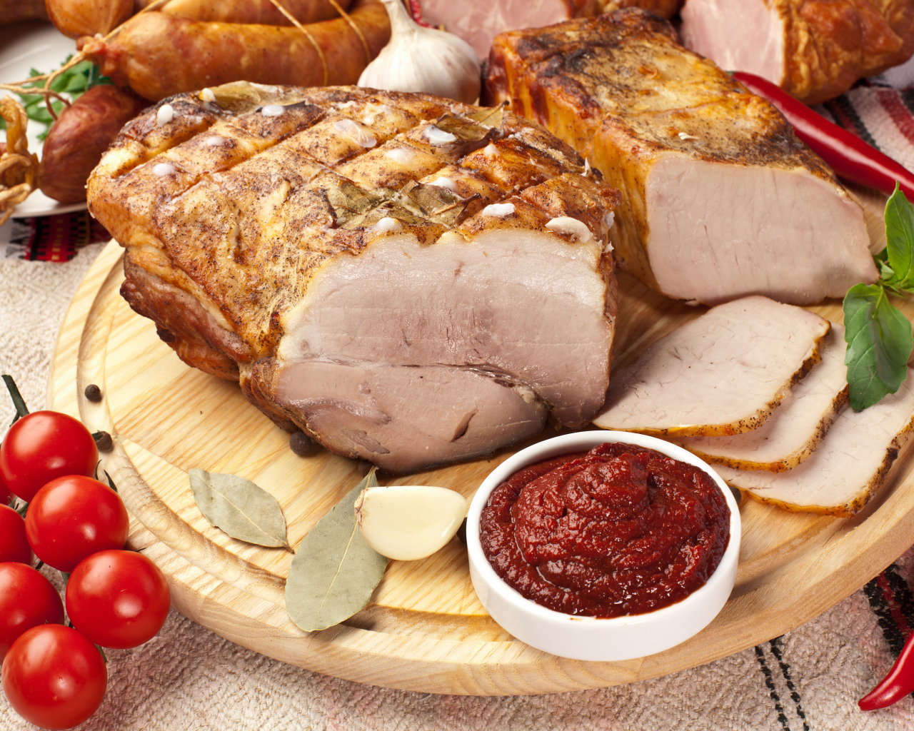 Аппетитная ветчина на столе с соусом и помидорами