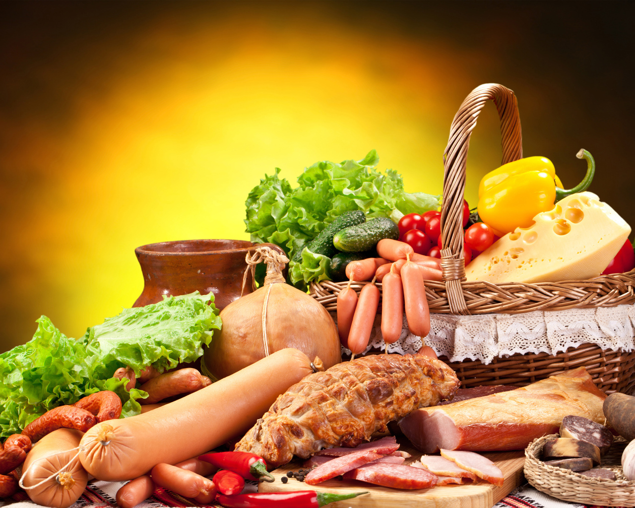Аппетитные мясные продукты на столе с корзиной овощей
