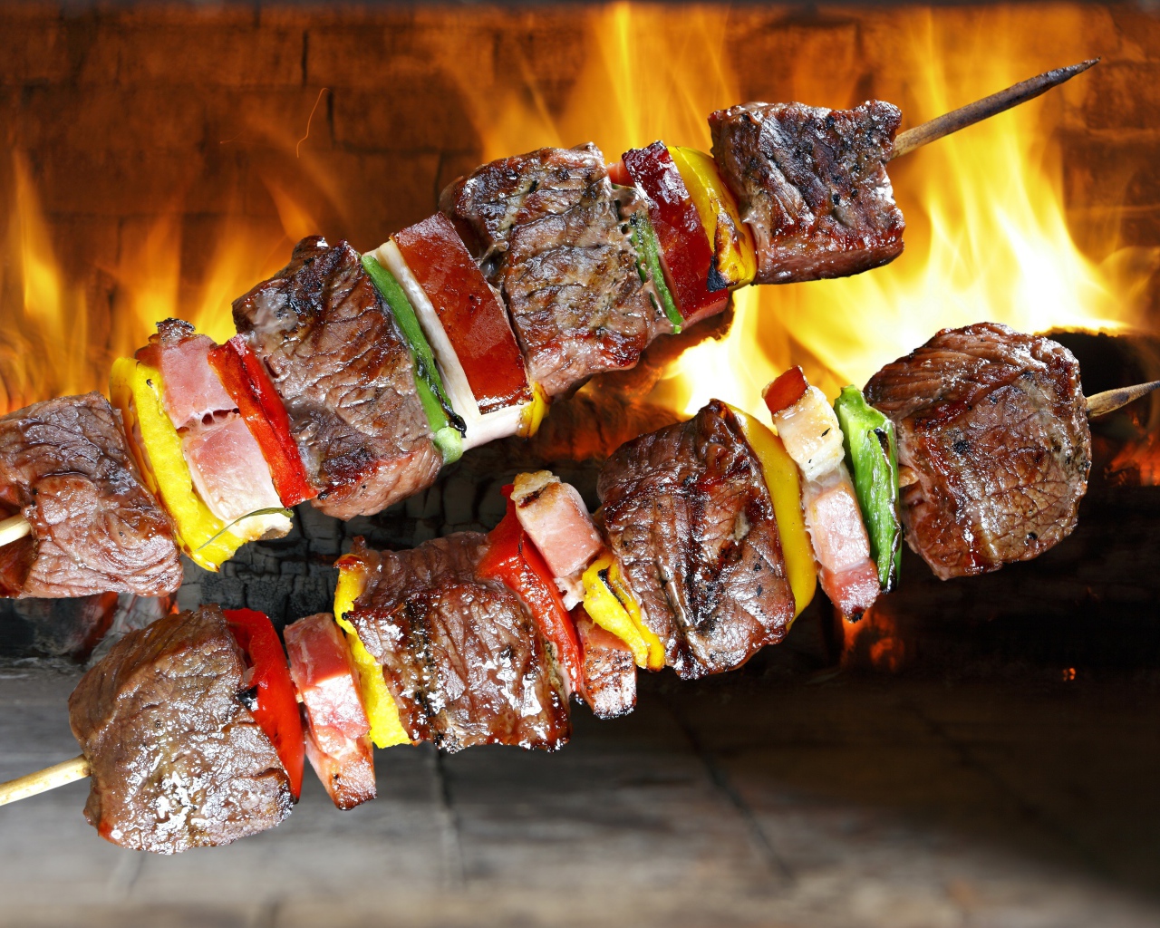 Аппетитный шашлык с овощами на фоне огня