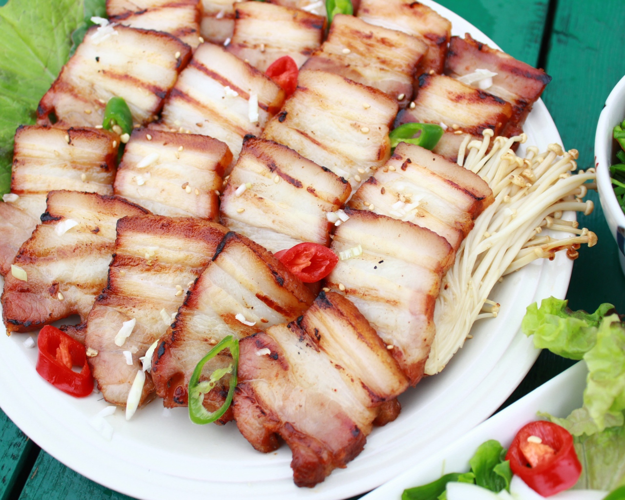 Аппетитное копченое сало на столе с овощами