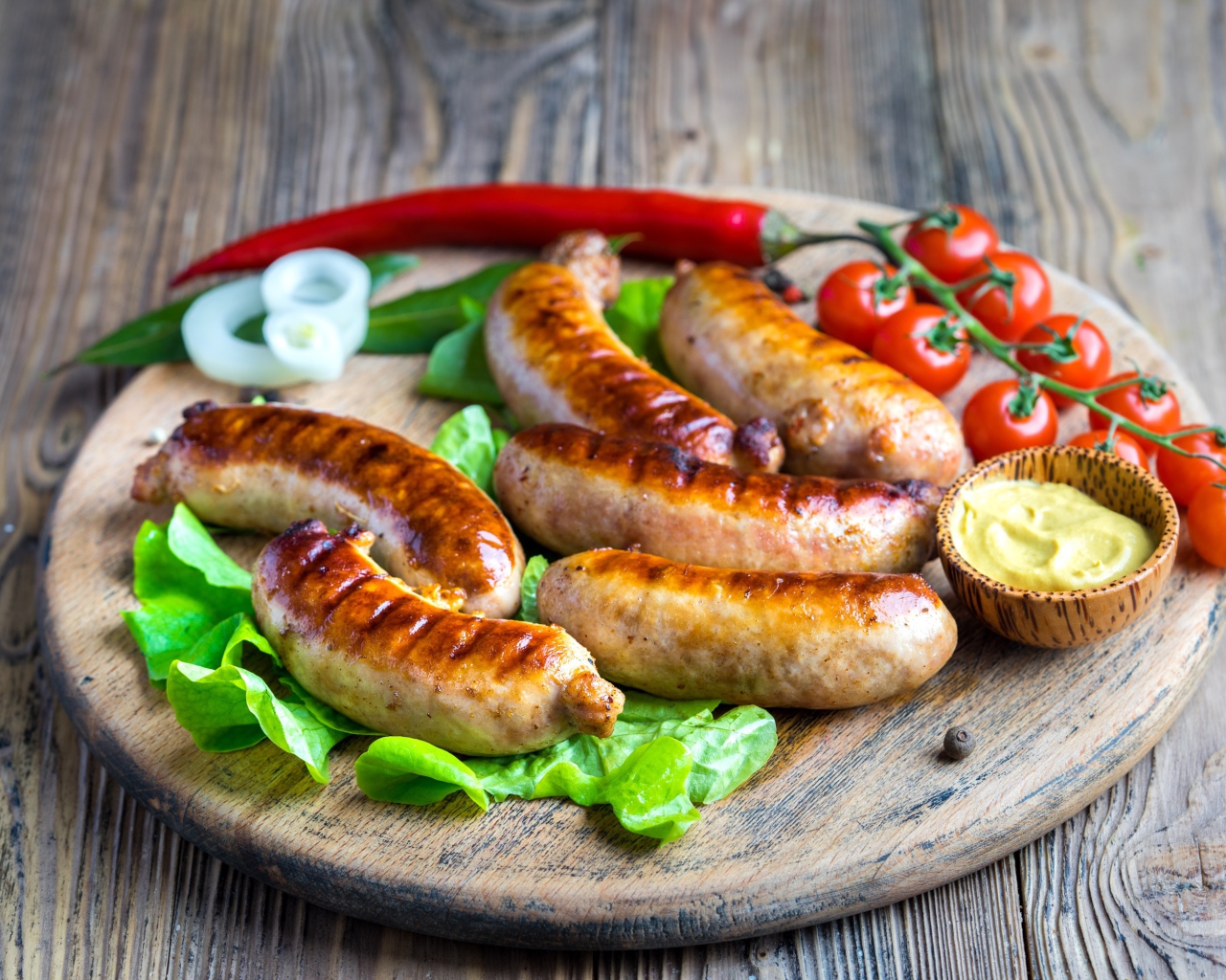 Сосиски барбекю с красным перцем и помидорами на разделочной доске