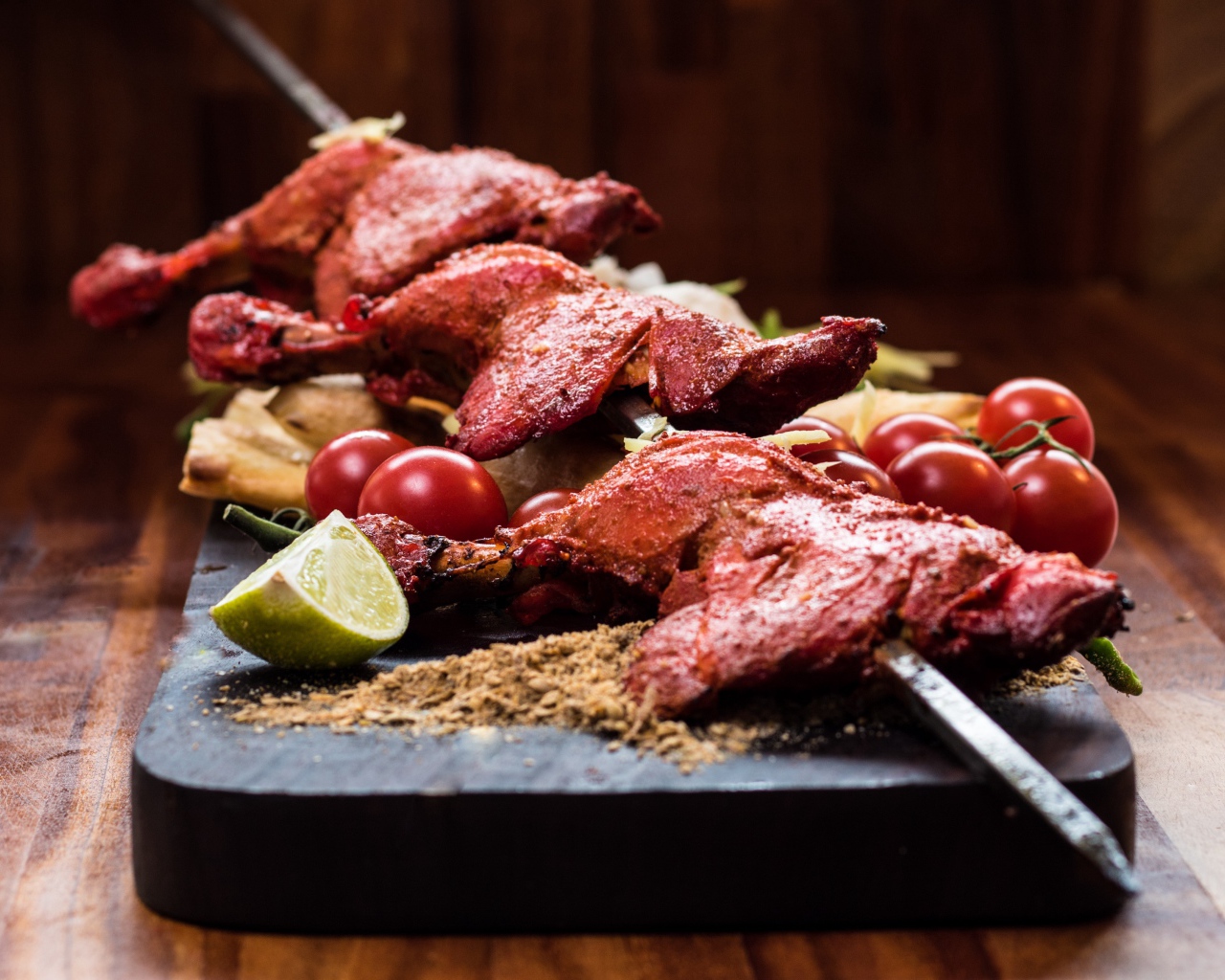 Курица жареная на шампурах на столе с овощами 