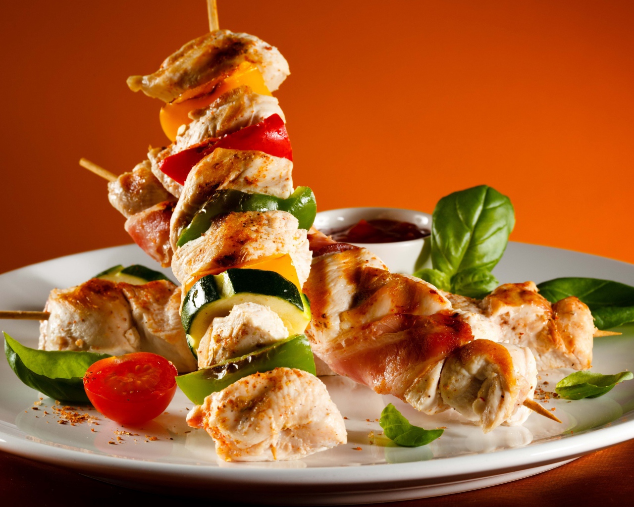 Куриные шашлыки с овощами на белой тарелке