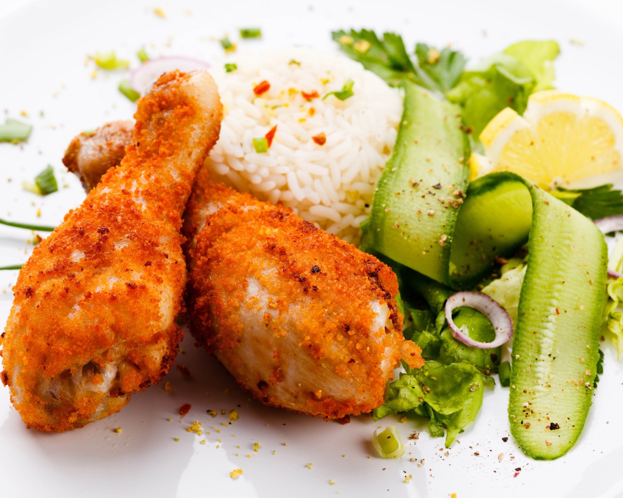 Куриные ножки с рисом и салатом на белой тарелке