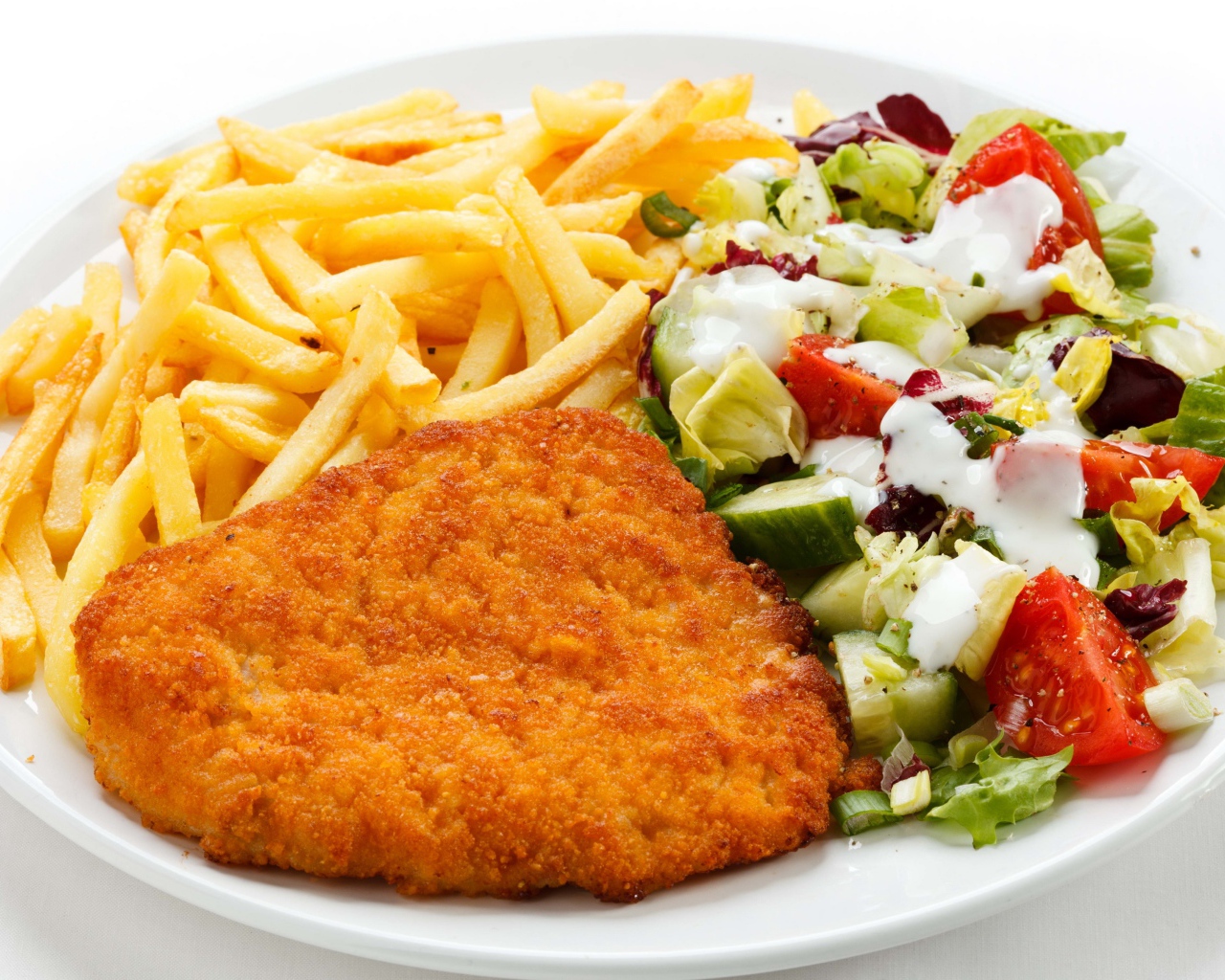 Отбивная на тарелке с картофелем фри и салатом
