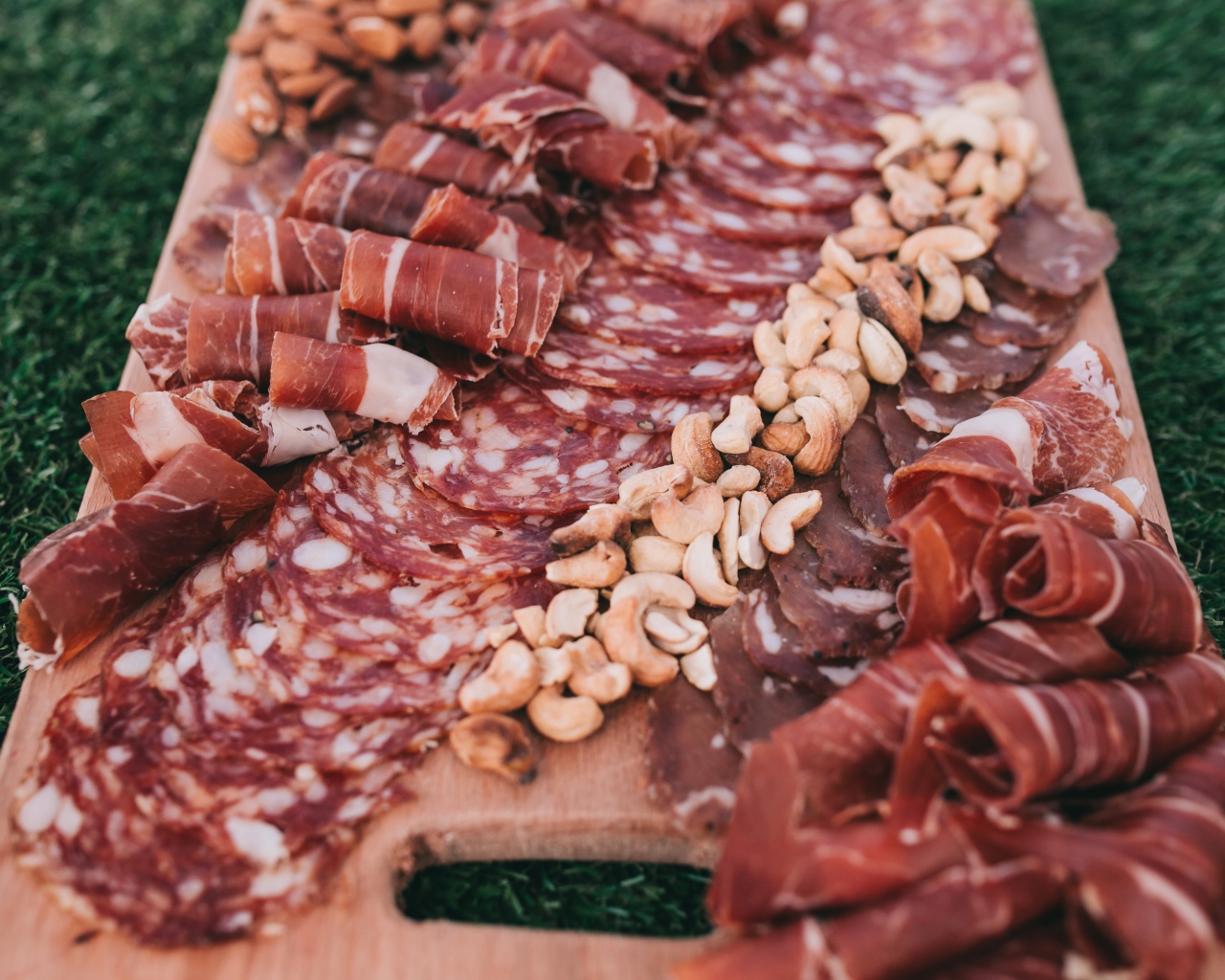 Мясная нарезка с орехами на разделочной доске