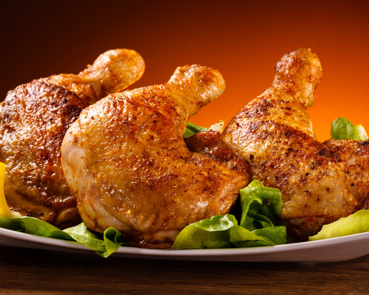 Жареные куриные окорочка на зеленых листьях салата 