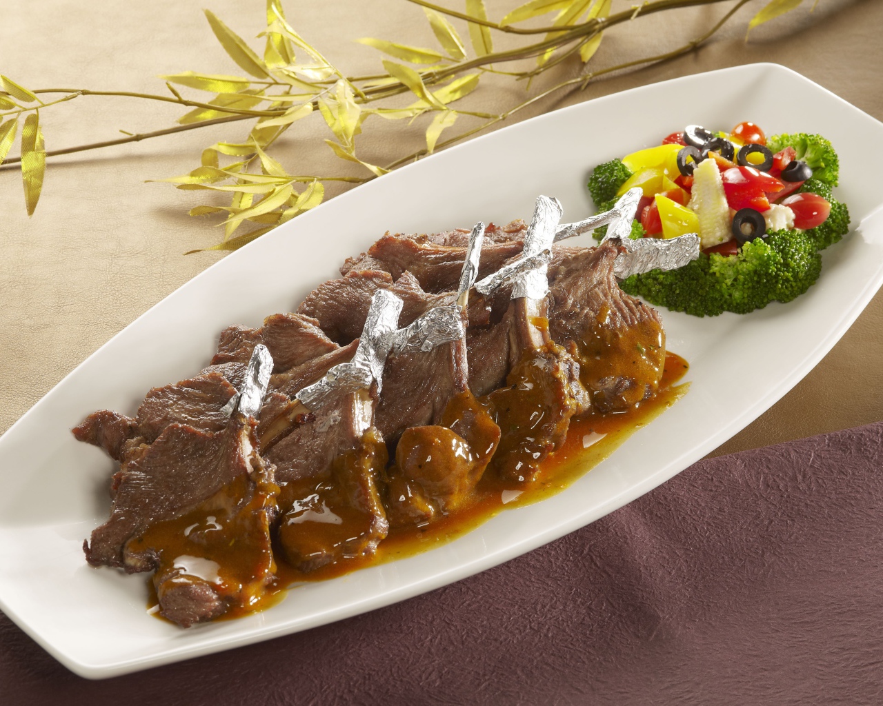 Мясо на белой тарелке с соусом и овощами 