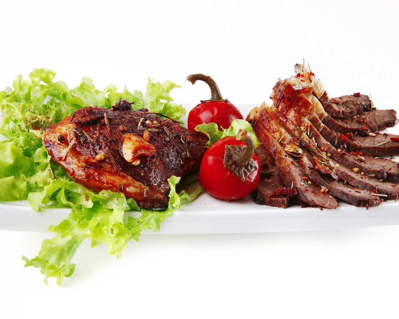 Мясо с листьями салата и красным перцем на белом фоне