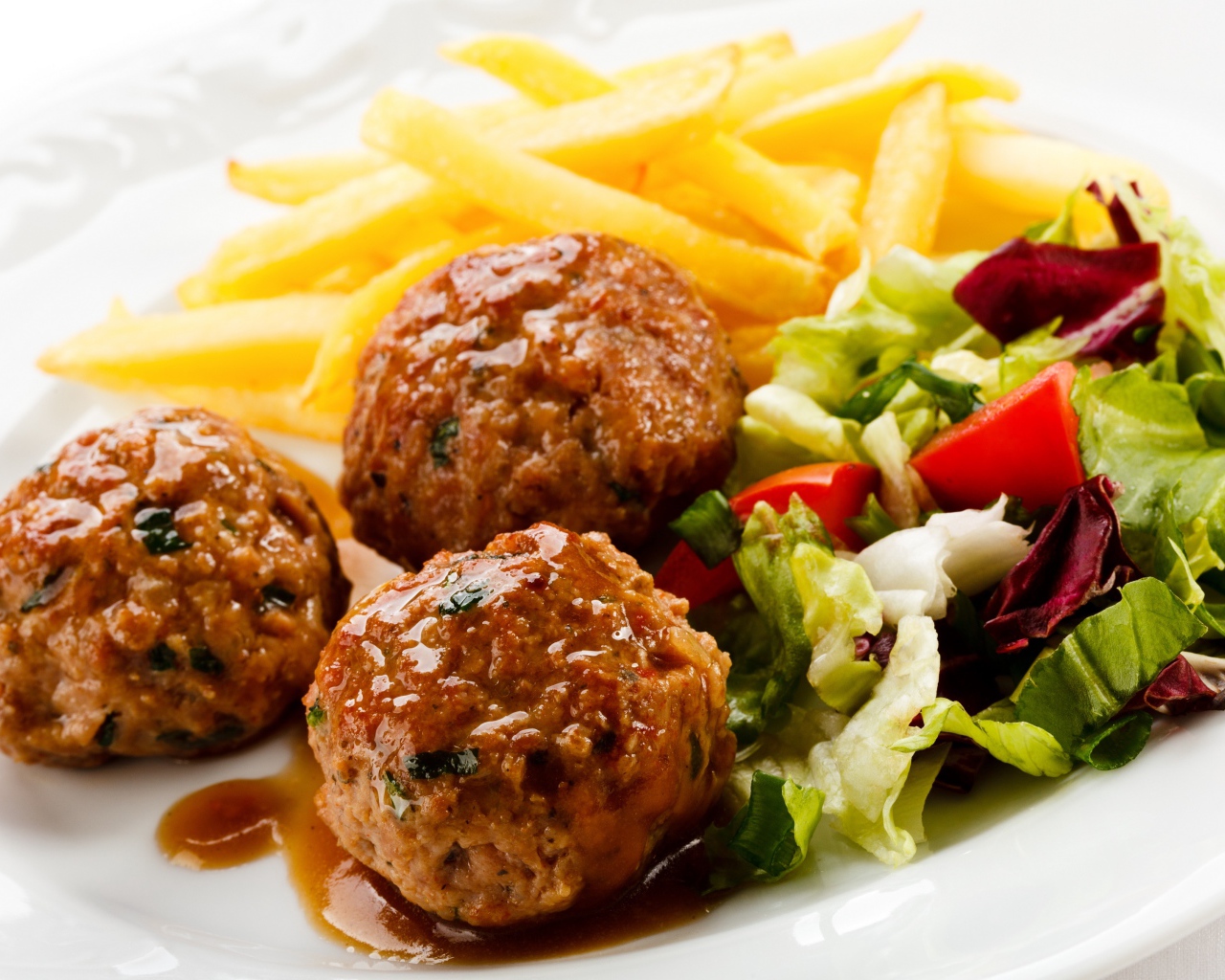 Тефтели с картофелем фри и салатом на белой тарелке 