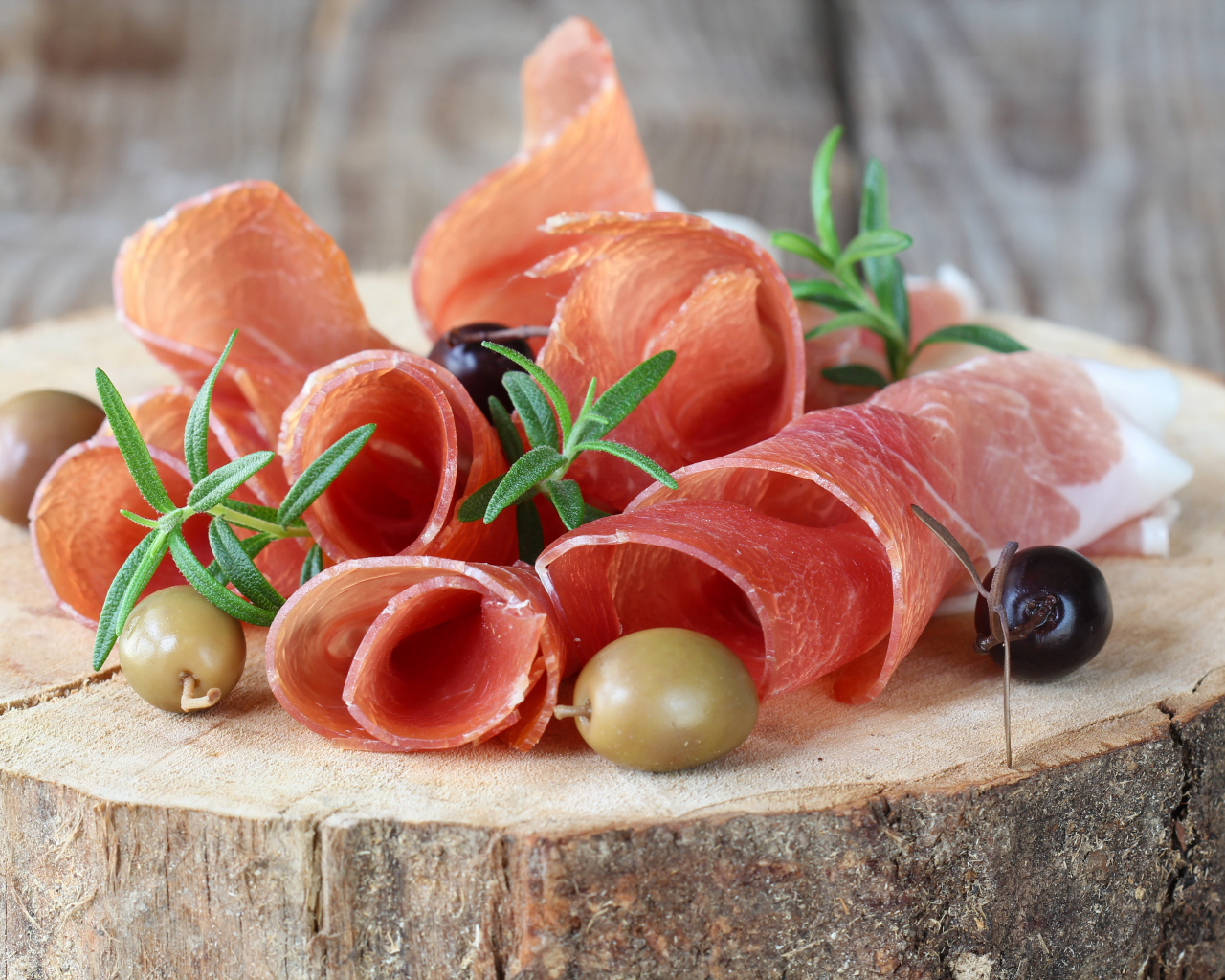 Прошутто  с оливками на деревянном столе 