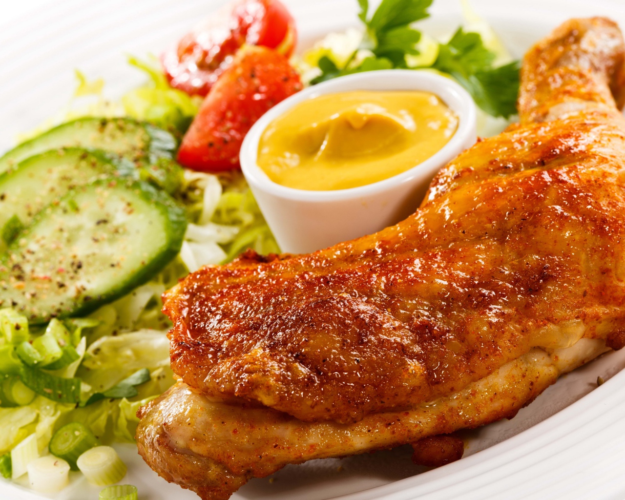 Жареная куриная ножка с овощами и соусом на тарелке