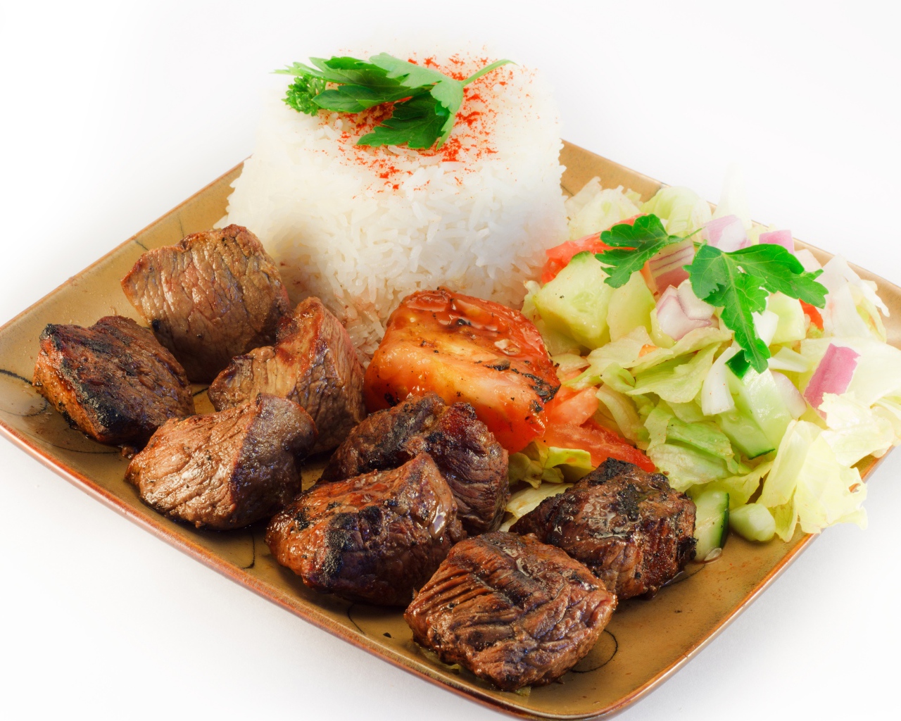Шашлык с рисом и овощами в тарелке на белом фоне