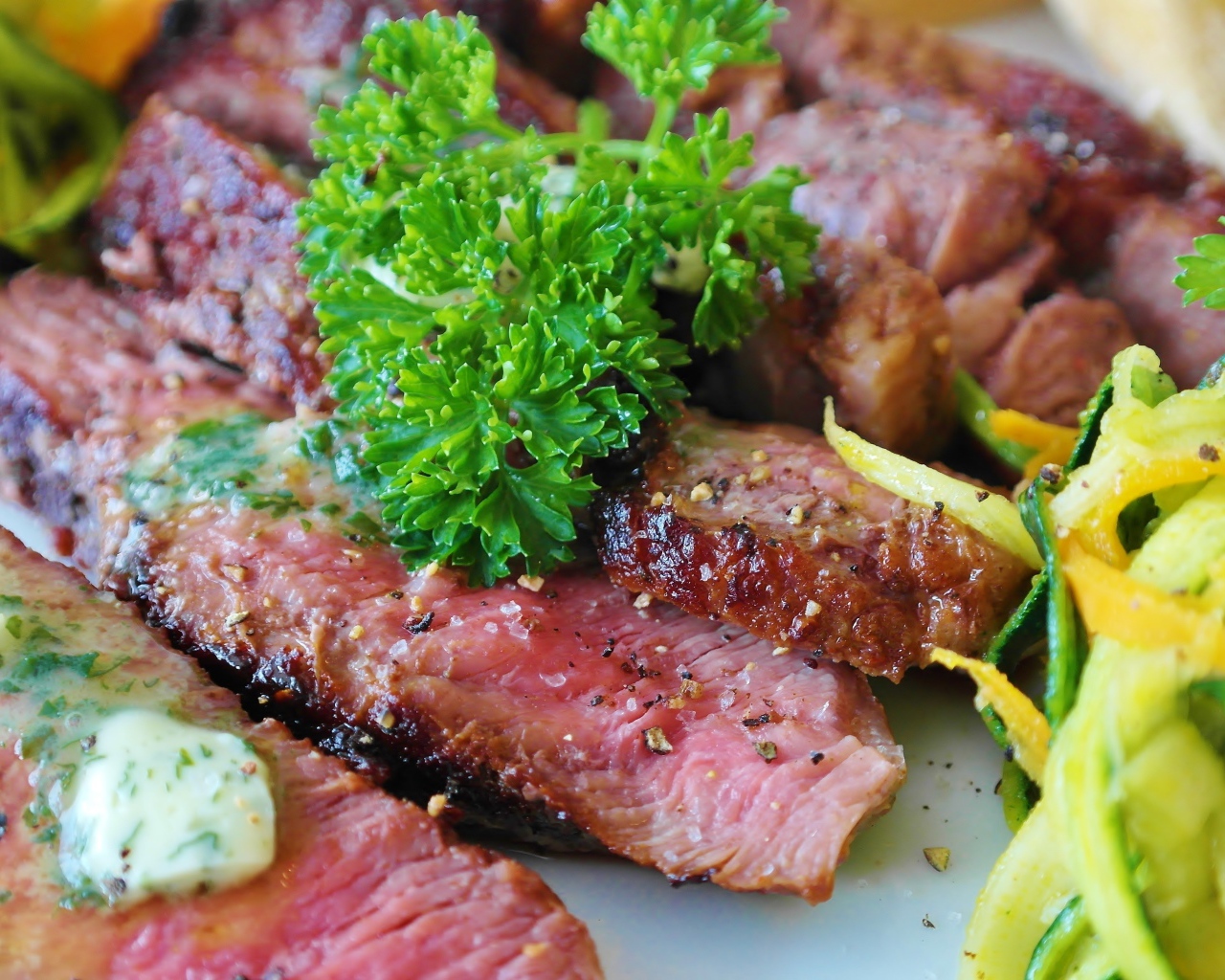 Нарезанный аппетитный кусок мяса с салатом и зеленью петрушки