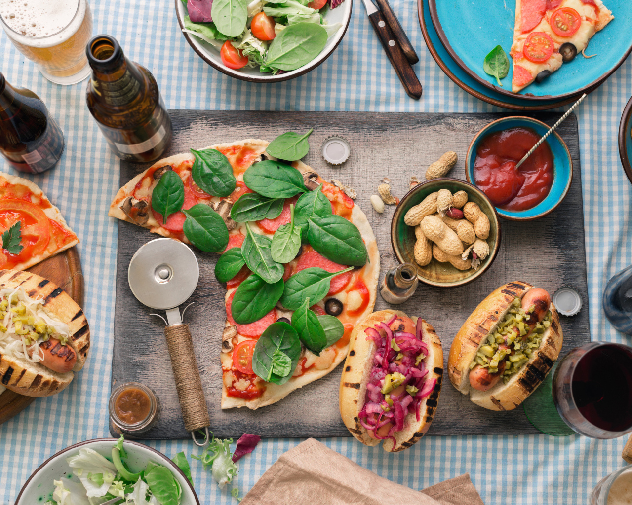 Пицца с хотдогами на столе с соусом