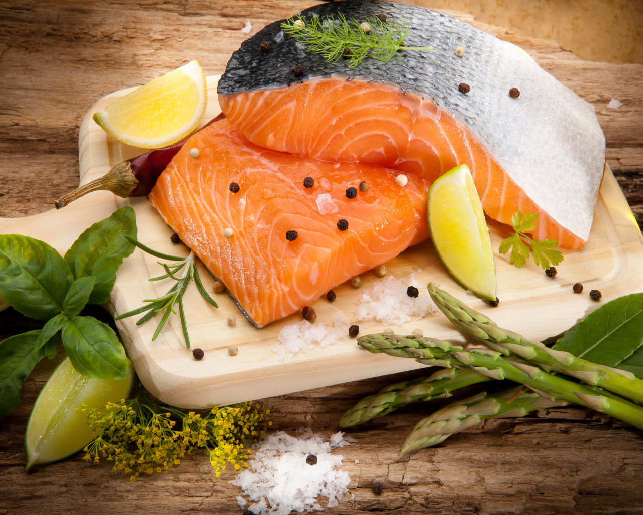 Филе красной рыбой на столе со спаржей и лаймом