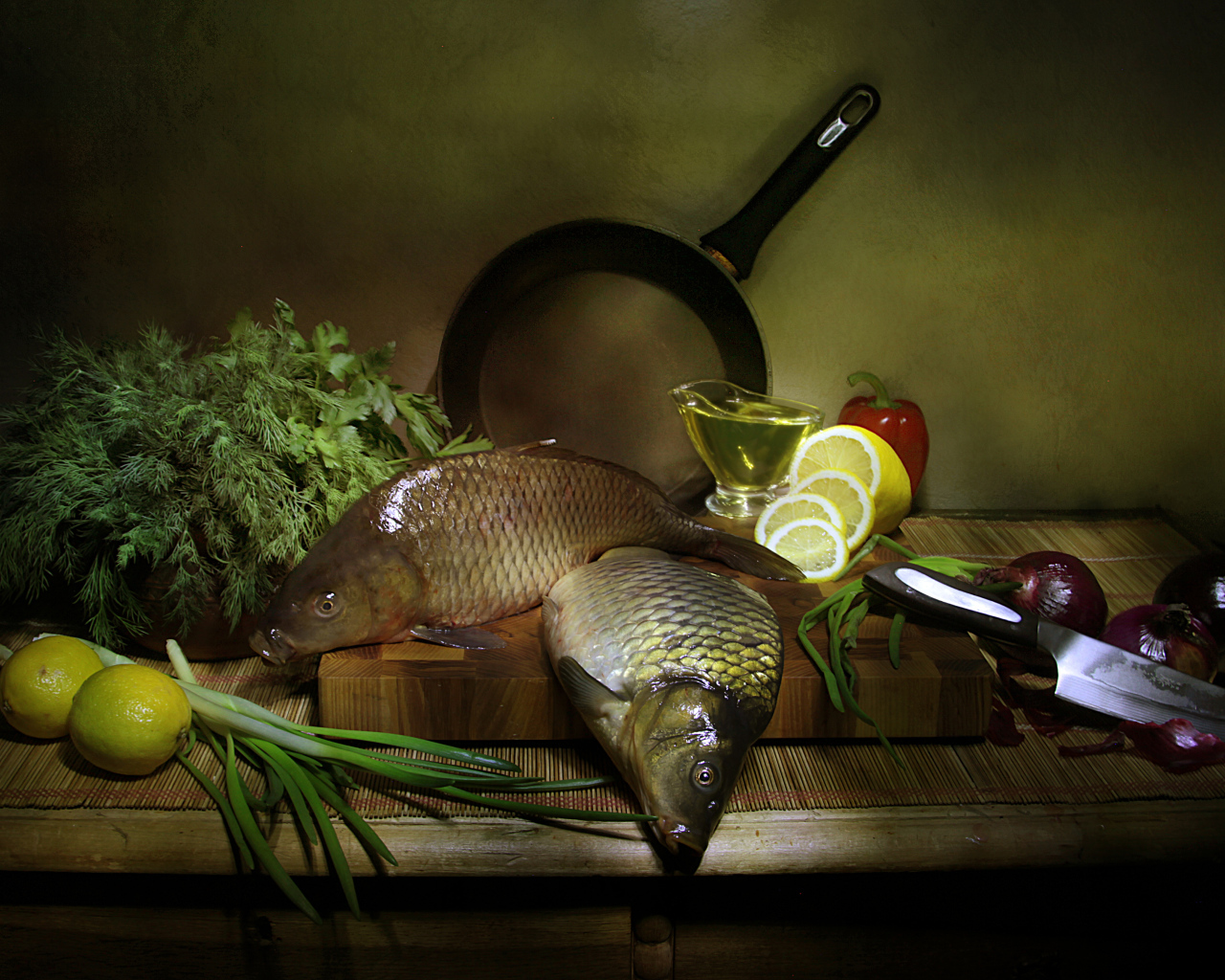 Сырая рыба на столе с зеленью, лимонами и луком 