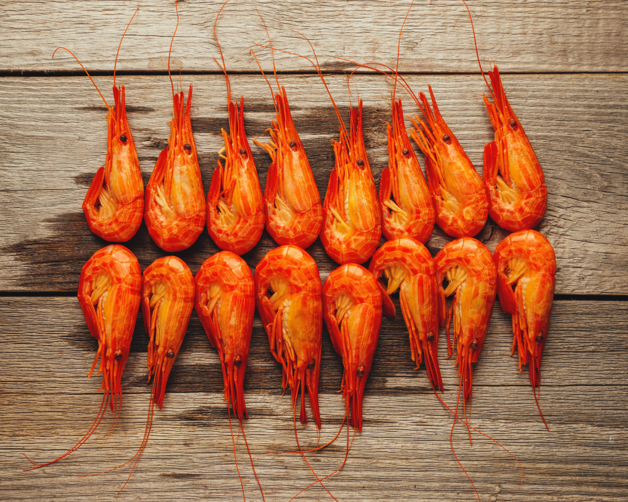 Красные вареные креветки на деревянном столе