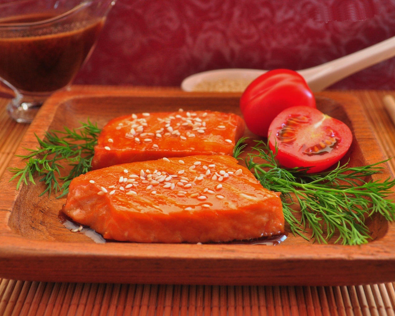 Красная рыба с кунжутом на тарелке с помидорами и укропом