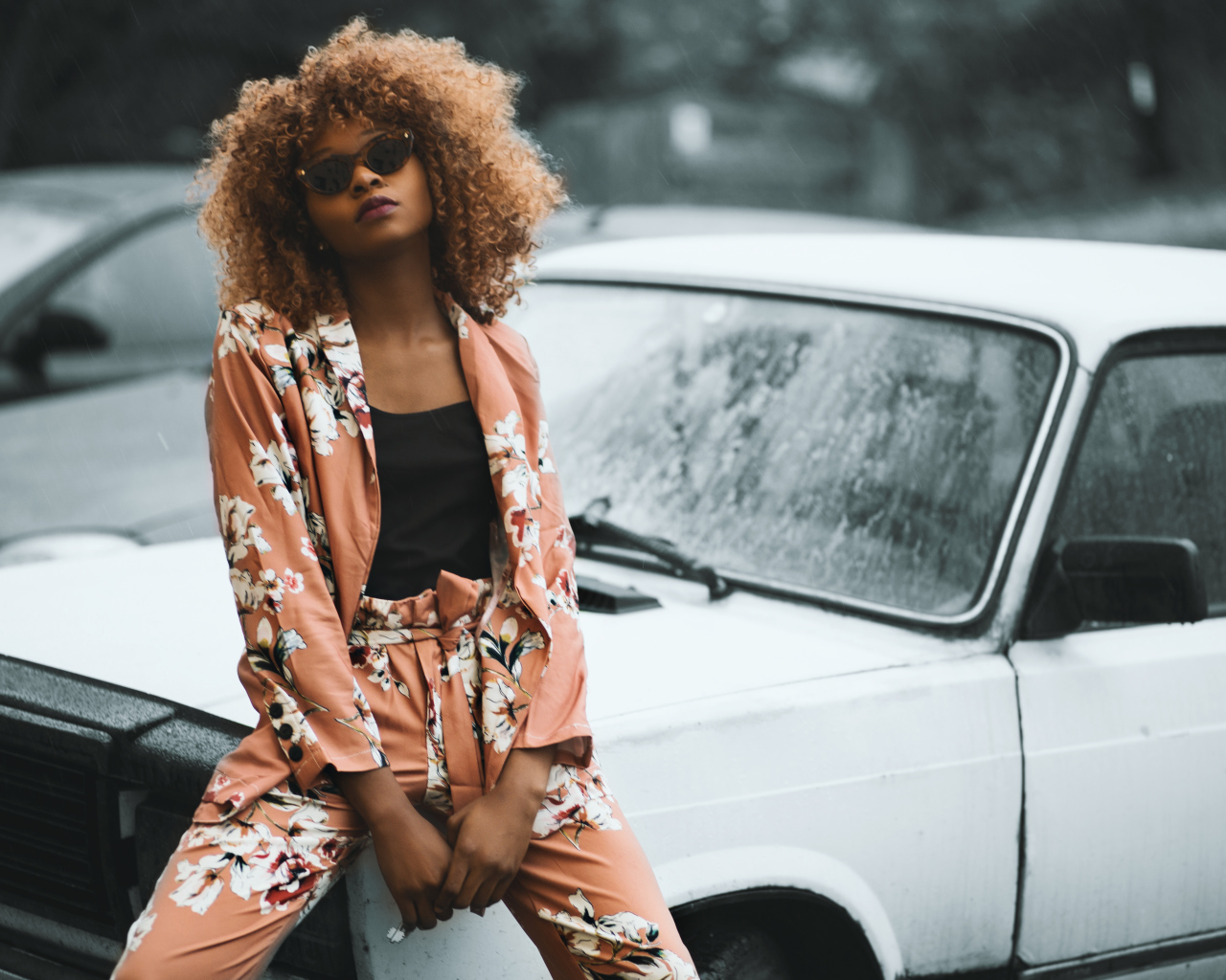 Красивая темнокожая девушка сидит на автомобиле 