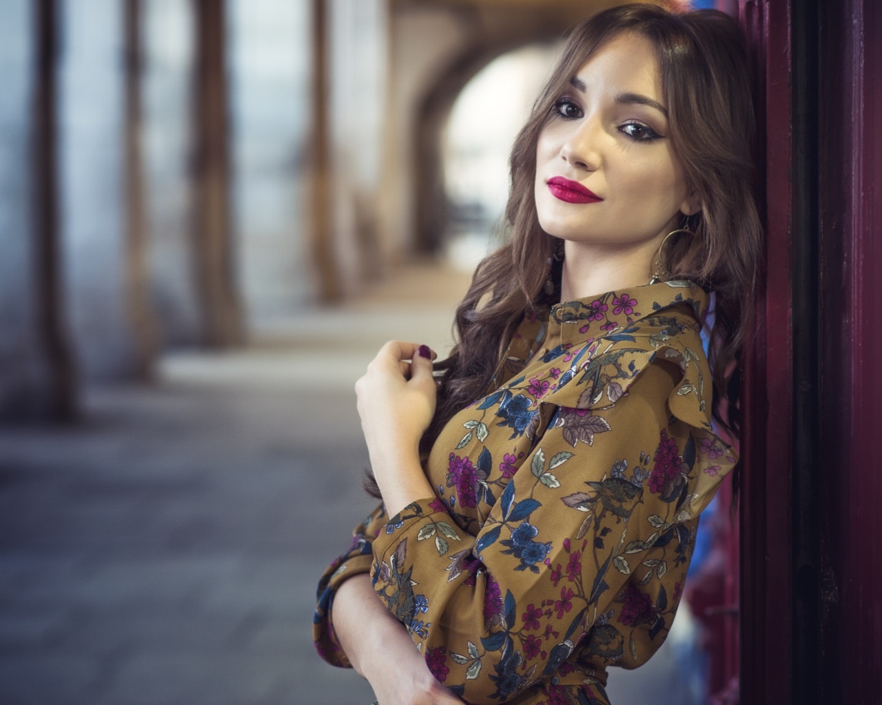 Девушка шатенка в красивом платье у стены