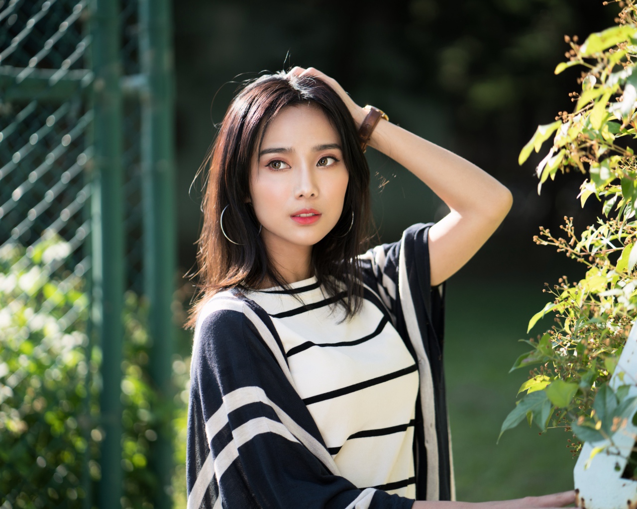 Красивая девушка азиатка с часами на руке 