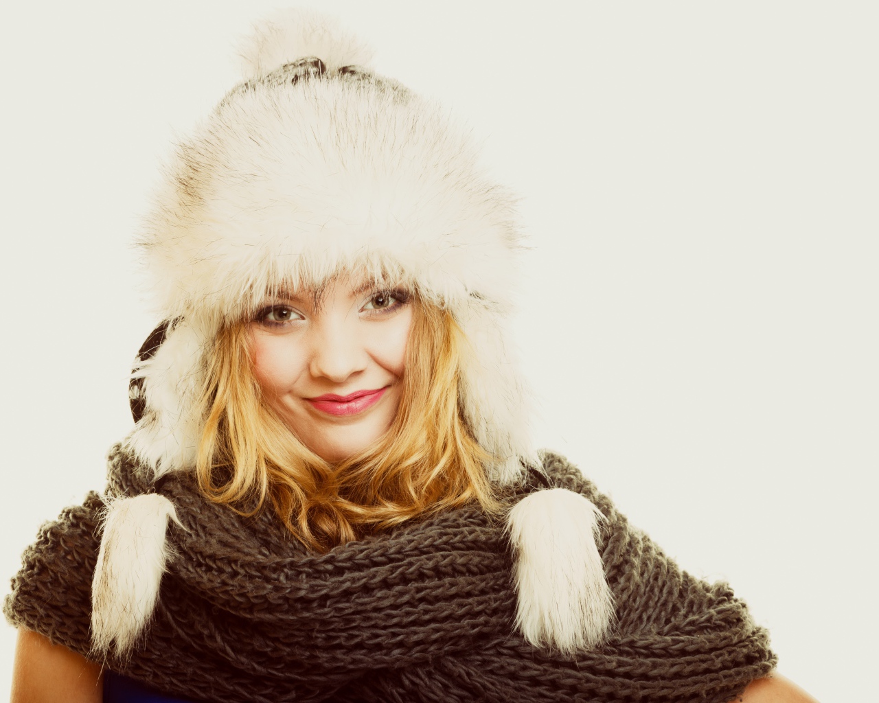 Красивая блондинка в теплой шапке с шарфом на шее