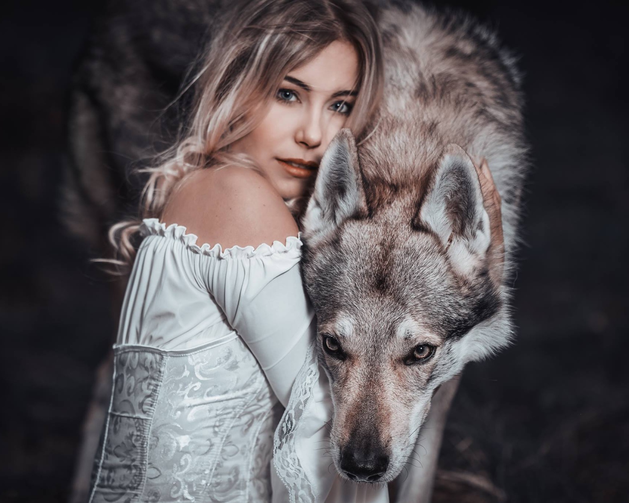 Красивая блондинка в белом платье с волком
