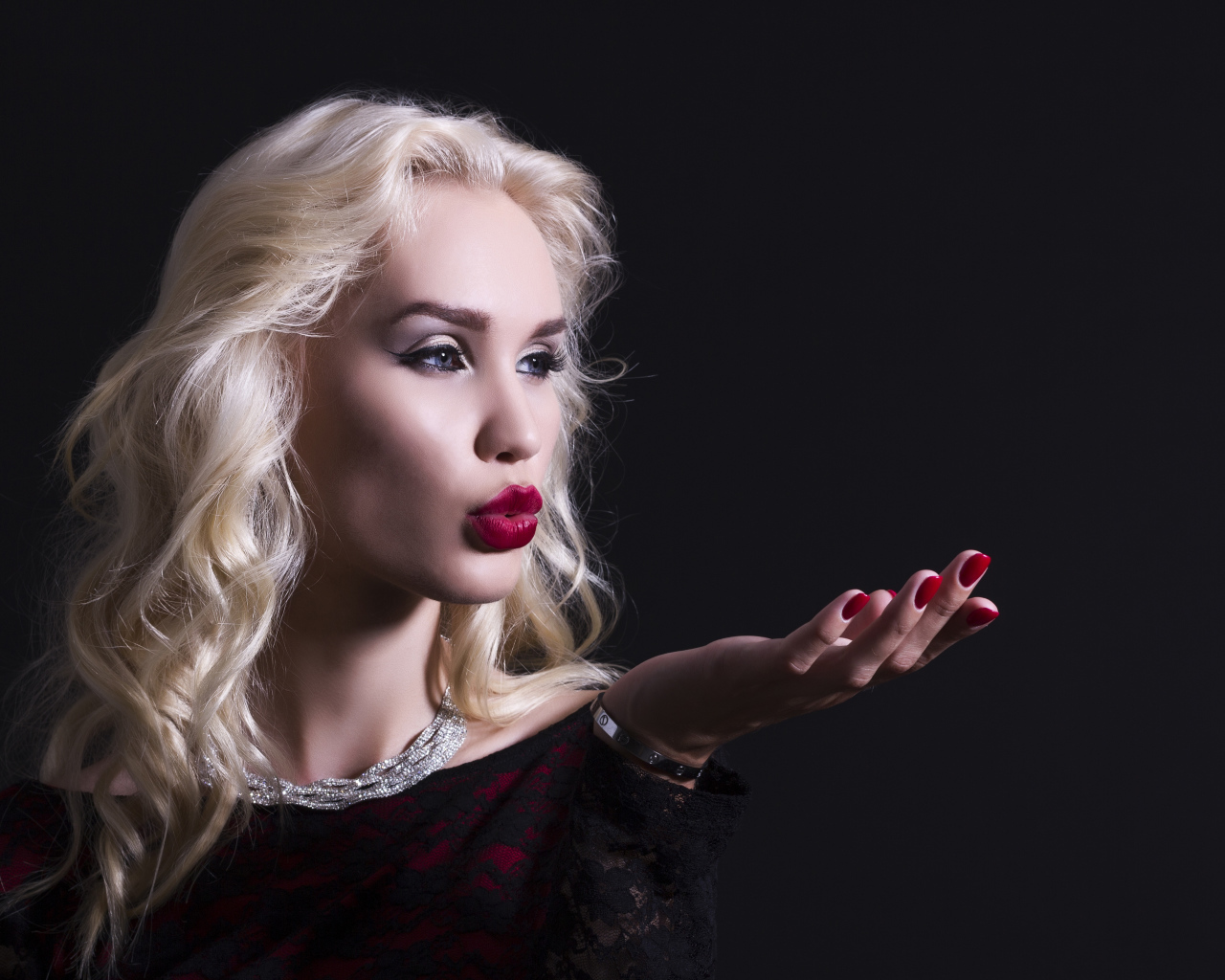 Красивая голубоглазая блондинка с красными губами в черном платье
