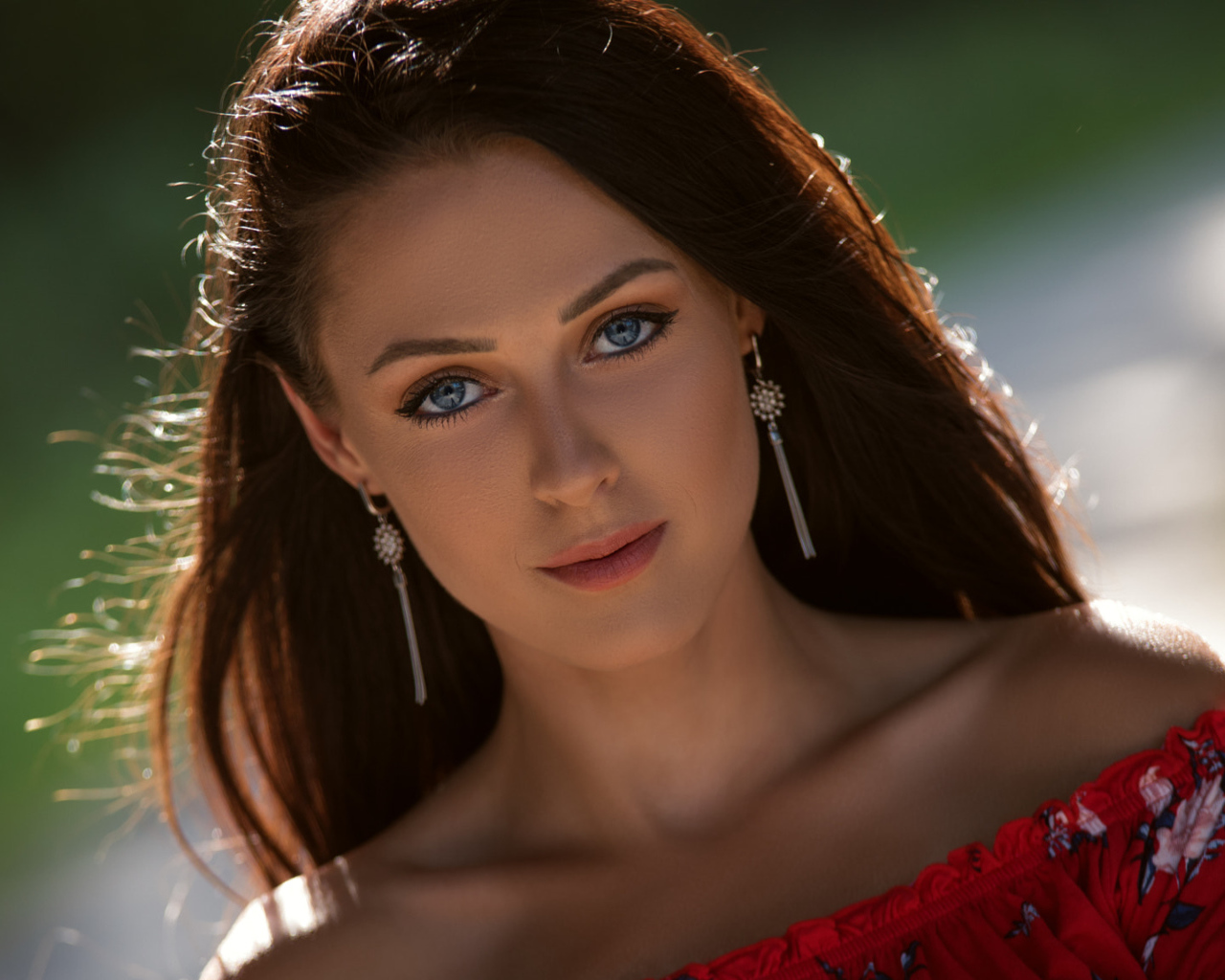 Красивая голубоглазая брюнетка с серьгами у ушах